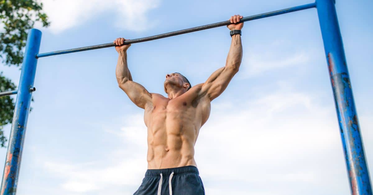 Strong athlete with sixpack is doing a pull-up