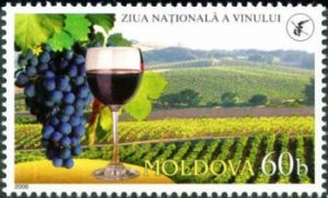 Moldavische postzegel met tros druiven, wijngaard en glas wijn afgebeeld.