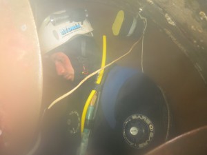 A diver-technician working in a closed-off thruster tunnel